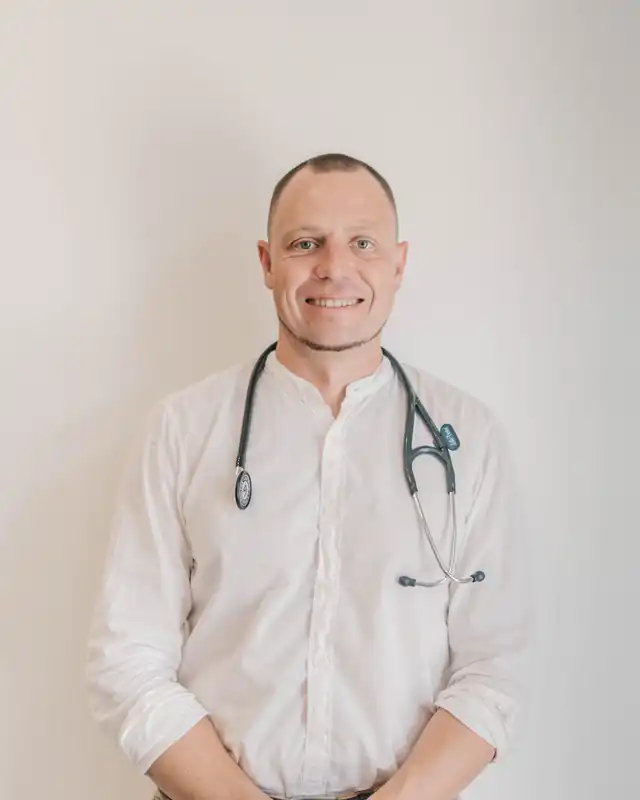 Andrey Hudson, médico, de camisa branca com estetoscópio ao pescoço.